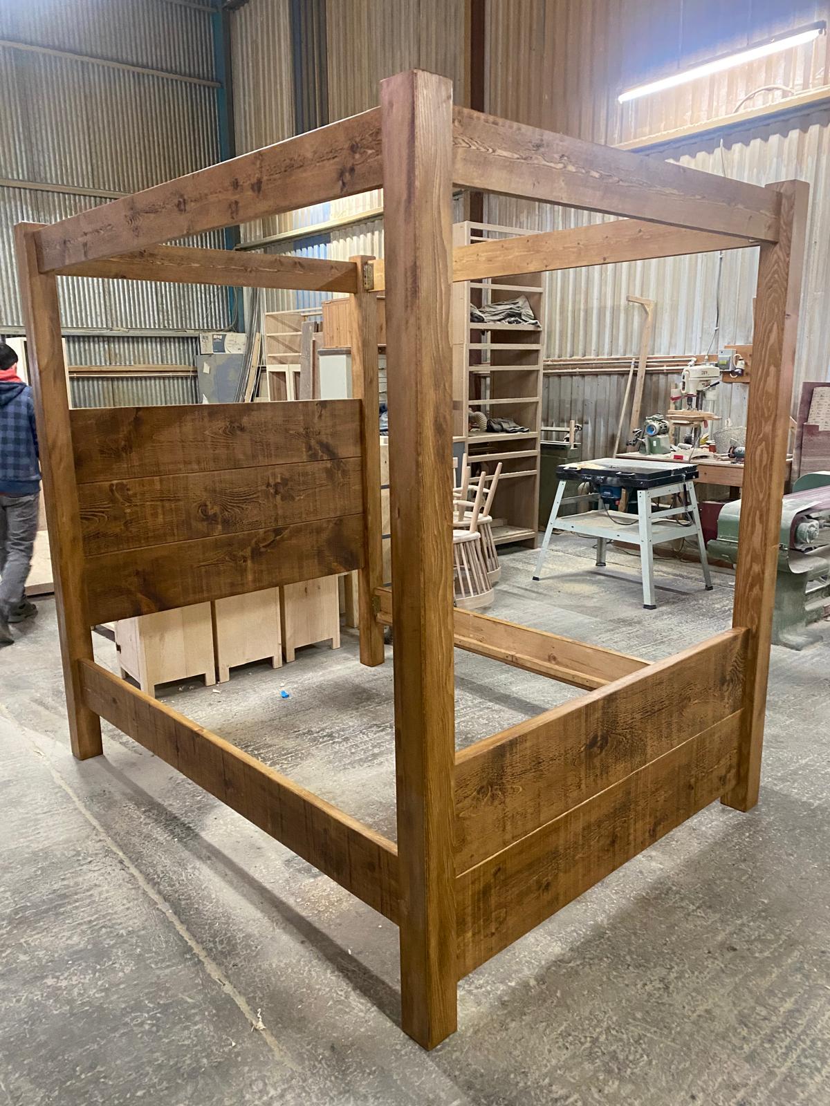 Handmade wooden four-poster bed frame in the workshop